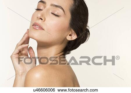 MODEL RELEASED. Young woman touching face with eyes closed, portrait. View Large Photo Image Stock Photograph - MODEL RELEASED. Young woman touching face with eyes closed, portrait.. Fotosearch