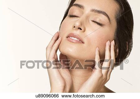MODEL RELEASED. Young woman touching face with eyes closed, portrait. View Large Photo Image Stock Photograph - MODEL RELEASED. Young woman touching face with eyes closed, portrait.. Fotosearch
