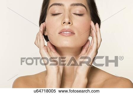 MODEL RELEASED. Young woman touching face with eyes closed, portrait. View Large Photo Image Stock Photography - MODEL RELEASED. Young woman touching face with eyes closed, portrait.. Fotosearch