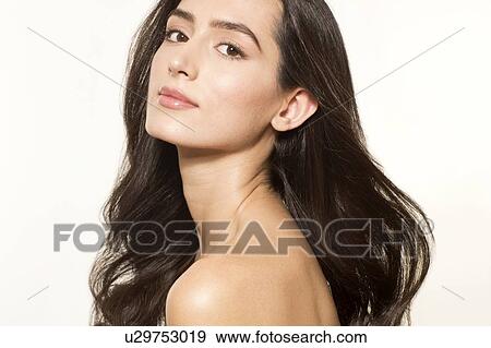 Stock Photo - MODEL RELEASED. Young woman with long brown hair looking at camera, portrait.. Fotosearch