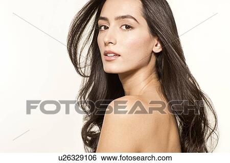 Stock Photograph - MODEL RELEASED. Young woman with long brown hair looking at camera, portrait.. Fotosearch