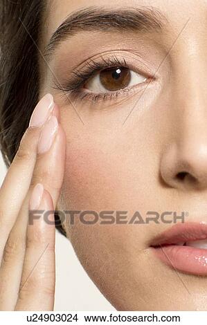 MODEL RELEASED. Young woman with fingers touching skin near eye, portrait. View Large Photo Image Picture - MODEL RELEASED. Young woman with fingers touching skin near eye, portrait.. Fotosearch