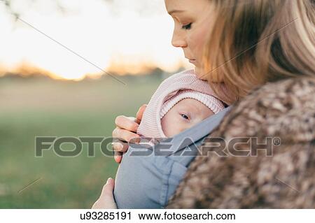 Mother and baby daughter outdoors, mother carrying baby in baby sling View Large Photo Image Stock Image - Mother and baby daughter outdoors, mother carrying baby in baby sling. Fotosearch