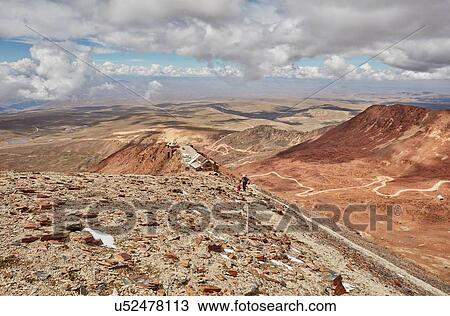 Stock Image - Mother and son, trekking across landscape, Chacaltaya, La Paz, Bolivia, South America. Fotosearch