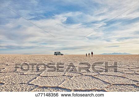 Stock Photograph - Mother and sons walking across salt flats, recreational vehicle in background, Salar de Uyuni, Uyuni, Oruro, Bolivia, South America. Fotosearch