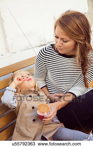Mother and toddler daughter eating ice cream on park bench View Large Photo Image Stock Image - Mother and toddler daughter eating ice cream on park bench. Fotosearch