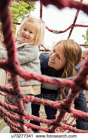 Mother and toddler daughter on playground climbing frame View Large Photo Image Stock Image - Mother and toddler daughter on playground climbing frame. Fotosearch