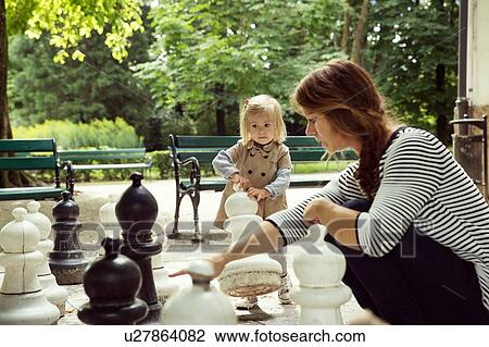 Mother and toddler daughter playing with giant chess in park View Large Photo Image Stock Image - Mother and toddler daughter playing with giant chess in park. Fotosearch