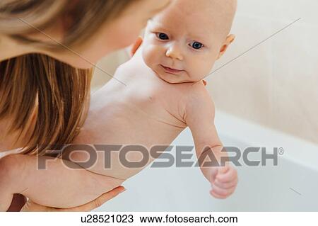 Stock Image - Mother bathing baby daughter. Fotosearch