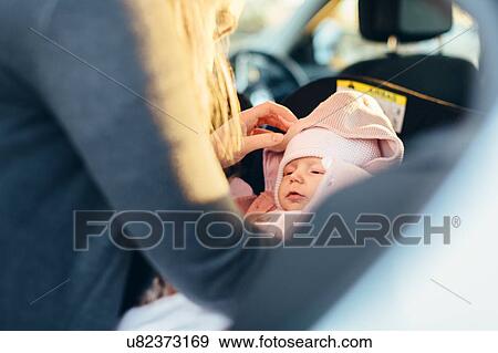 Mother fastening young baby in car seat, mid section View Large Photo Image Stock Photo - Mother fastening young baby in car seat, mid section. Fotosearch