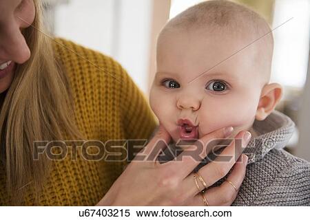 Mother squeezing baby's (12-17 months) face View Large Photo Image Stock Photography - Mother squeezing baby's (12-17 months) face. Fotosearch