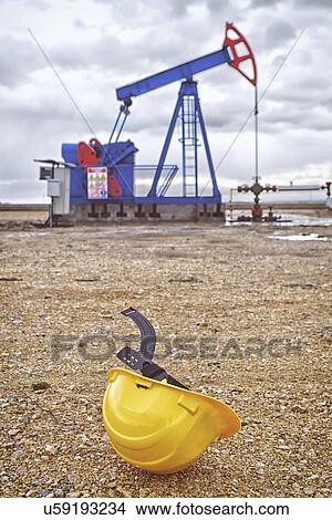 Picture - Oil pump and protective helmet.. Fotosearch