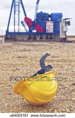 Stock Image - Oil pump and protective helmet.. Fotosearch