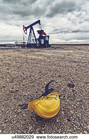 Stock Photo - Oil pump and protective helmet.. Fotosearch