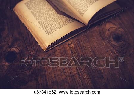 Stock Image - Old book on library desk.. Fotosearch