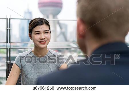 Over shoulder view of young businesswoman and man having meeting at sidewalk cafe in Shanghai financial centre, Shanghai, China View Large Photo Image Stock Photo - Over shoulder view of young businesswoman and man having meeting at sidewalk cafe in Shanghai financial centre, Shanghai, China. Fotosearch