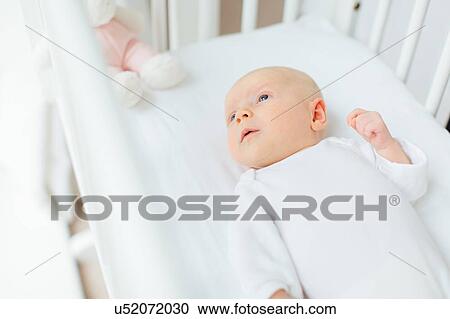 Overhead view of baby girl lying in crib View Large Photo Image Stock Image - Overhead view of baby girl lying in crib. Fotosearch