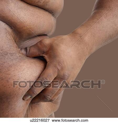 Stock Photo - Overweight man pinching body fat on his waist.. Fotosearch
