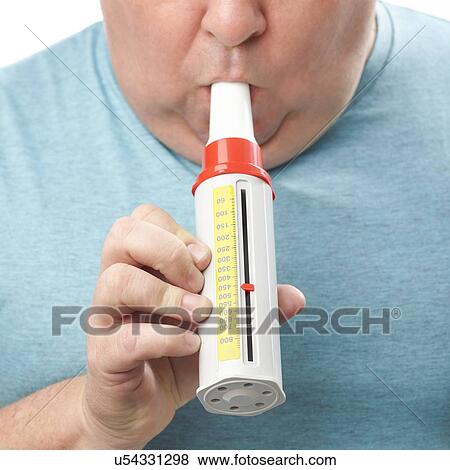 Stock Photo - Overweight man using a peak flow metre.. Fotosearch