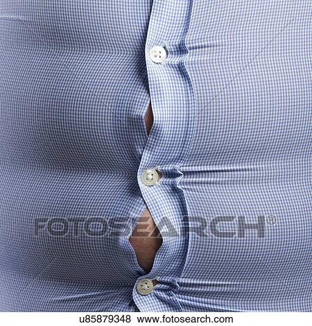 Stock Photo - Overweight man wearing blue shirt with bulging buttons.. Fotosearch