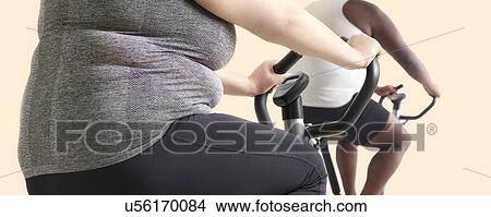 Overweight woman and man on exercise bikes. View Large Photo Image Picture - Overweight woman and man on exercise bikes.. Fotosearch