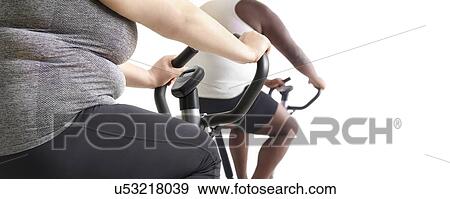 Overweight woman and man on exercise bikes. View Large Photo Image Stock Photo - Overweight woman and man on exercise bikes.. Fotosearch