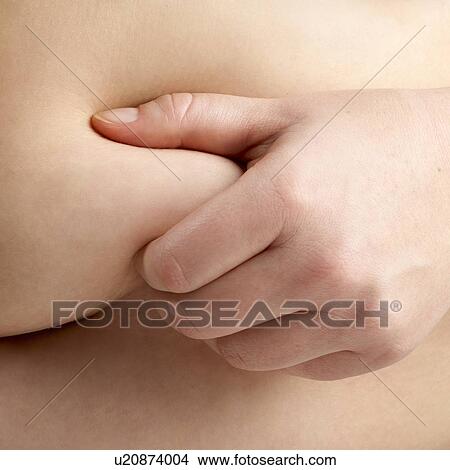 Picture - Overweight woman holding the fat around her waist, close up.. Fotosearch