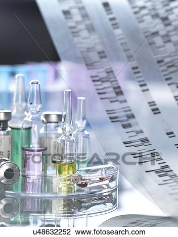 Stock Image - Personalised medicine, conceptual image. Variety of drugs sitting on a DNA (deoxyribonucleic acid) autoradiogram.. Fotosearch
