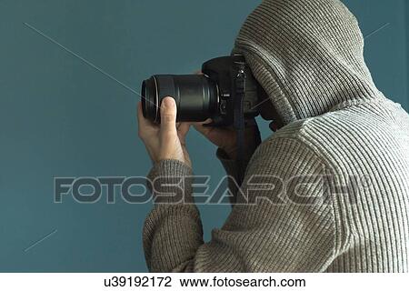 Stock Image - Photographer holding full frame sensor DSLR camera.. Fotosearch