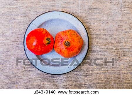 Stock Image - Plate of pomegranates on table. Fotosearch