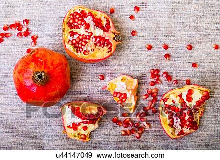 Stock Photo - Pomegranate pieces and seeds on table. Fotosearch