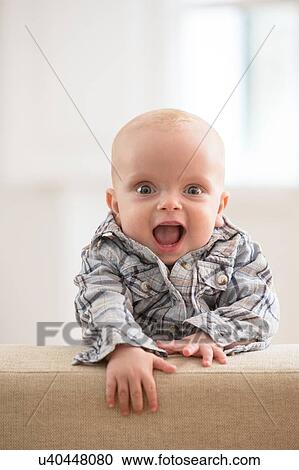 Stock Image - Portrait of baby boy, laughing. Fotosearch