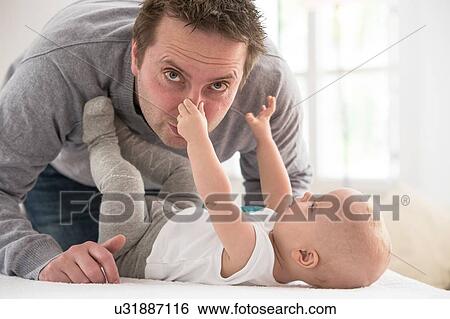 Portrait of baby boy lying on bed holding father's nose View Large Photo Image Stock Photograph - Portrait of baby boy lying on bed holding father's nose. Fotosearch