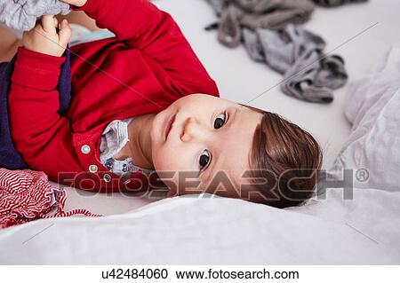 Portrait of baby girl lying on bed View Large Photo Image Stock Image - Portrait of baby girl lying on bed. Fotosearch