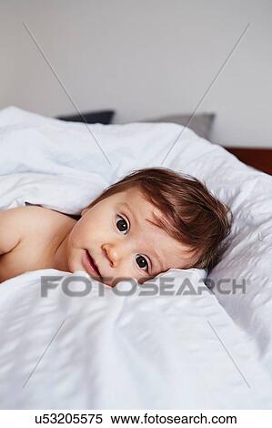 Portrait of baby girl lying on bed View Large Photo Image Stock Photography - Portrait of baby girl lying on bed. Fotosearch