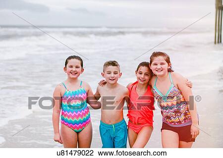Stock Image - Portrait of boy and three girls on beach, Dauphin Island, Alabama, USA. Fotosearch