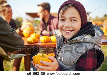 Stock Photograph - Portrait of boy holding harvested vegetable squash. Fotosearch