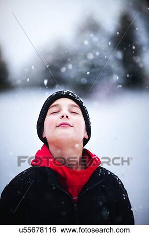 Stock Photograph - Portrait of boy in falling snow. Fotosearch