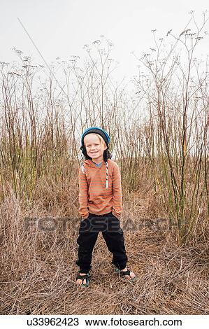 Portrait of boy in rural setting, hands in pockets, smiling View Large Photo Image Stock Image - Portrait of boy in rural setting, hands in pockets, smiling. Fotosearch