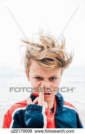 Portrait of boy on beach, messy hair, poking finger up nose, close-up View Large Photo Image Stock Photo - Portrait of boy on beach, messy hair, poking finger up nose, close-up. Fotosearch