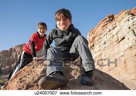 Portrait of boys sitting on rock looking at camera, sticking out tongue, Lone Pine, California, USA View Large Photo Image Stock Photo - Portrait of boys sitting on rock looking at camera, sticking out tongue, Lone Pine, California, USA. Fotosearch