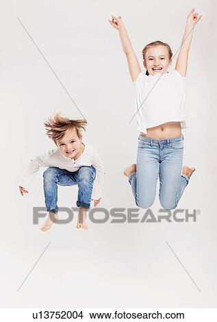 Portrait of brother and sister leaping in air View Large Photo Image Picture - Portrait of brother and sister leaping in air. Fotosearch