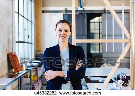 Portrait of businesswoman in office, arms folded, smiling View Large Photo Image Stock Image - Portrait of businesswoman in office, arms folded, smiling. Fotosearch