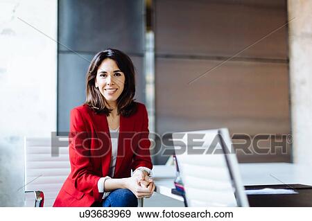 Stock Photo - Portrait of businesswoman in office, smiling. Fotosearch