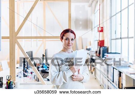 Portrait of casual businesswoman in office, holding paperwork View Large Photo Image Stock Photo - Portrait of casual businesswoman in office, holding paperwork. Fotosearch