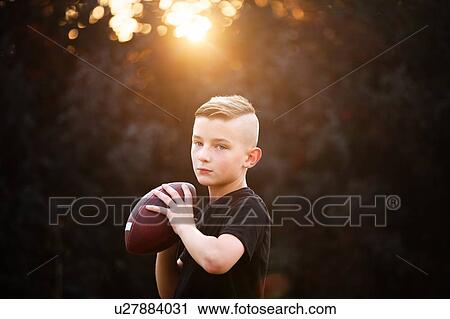 Portrait of confident boy practicing american football, holding ball in garden View Large Photo Image Stock Image - Portrait of confident boy practicing american football, holding ball in garden. Fotosearch