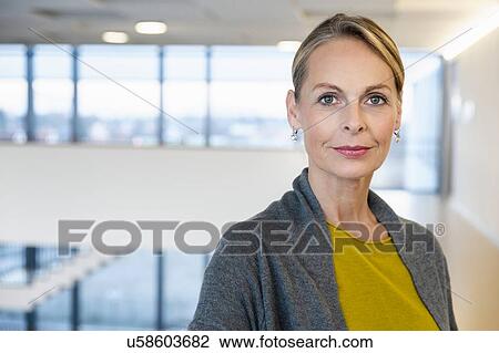 Stock Image - Portrait of confident mature businesswoman in office atrium. Fotosearch
