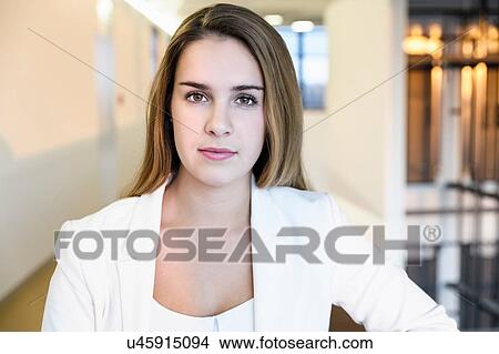 Picture - Portrait of confident young businesswoman in office corridor, head and shoulders. Fotosearch