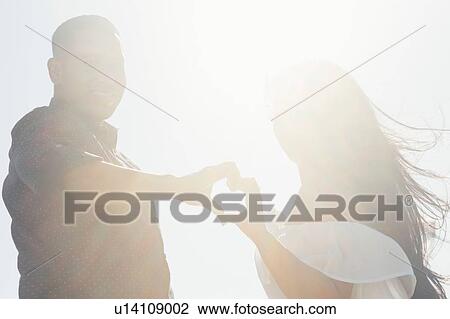 Portrait of couple outdoors, hands touching, making heart shape View Large Photo Image Stock Image - Portrait of couple outdoors, hands touching, making heart shape. Fotosearch
