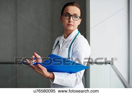 Portrait of doctor, holding clipboard. looking over shoulder View Large Photo Image Stock Photography - Portrait of doctor, holding clipboard. looking over shoulder. Fotosearch